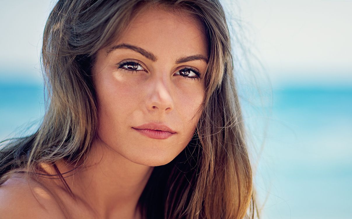 Woman with long hair near the ocean.