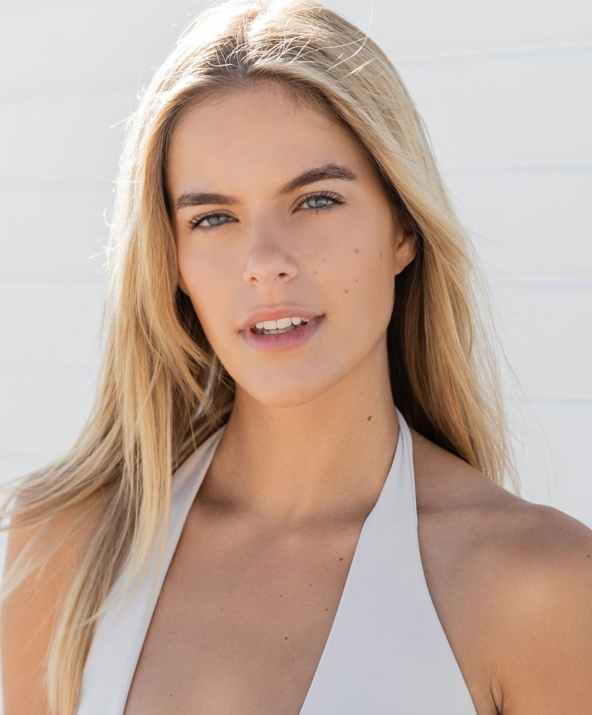 Young woman with long blonde hair, smiling.