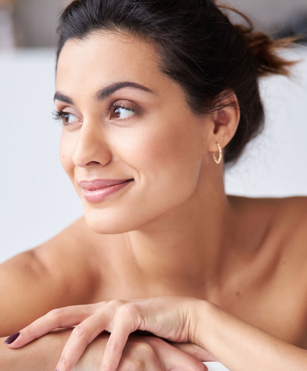 Smiling woman resting her chin on hands.