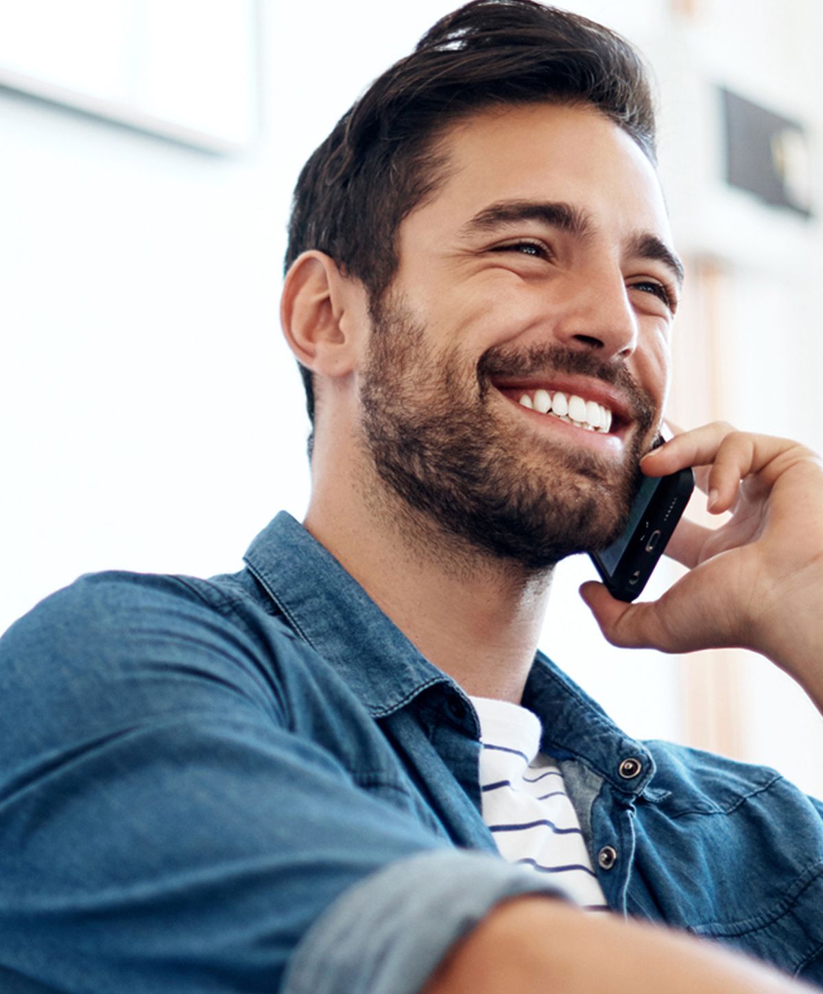 Man smiling while talking on the phone