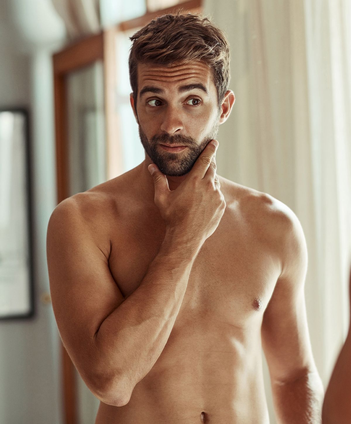 Man contemplating in front of a mirror.