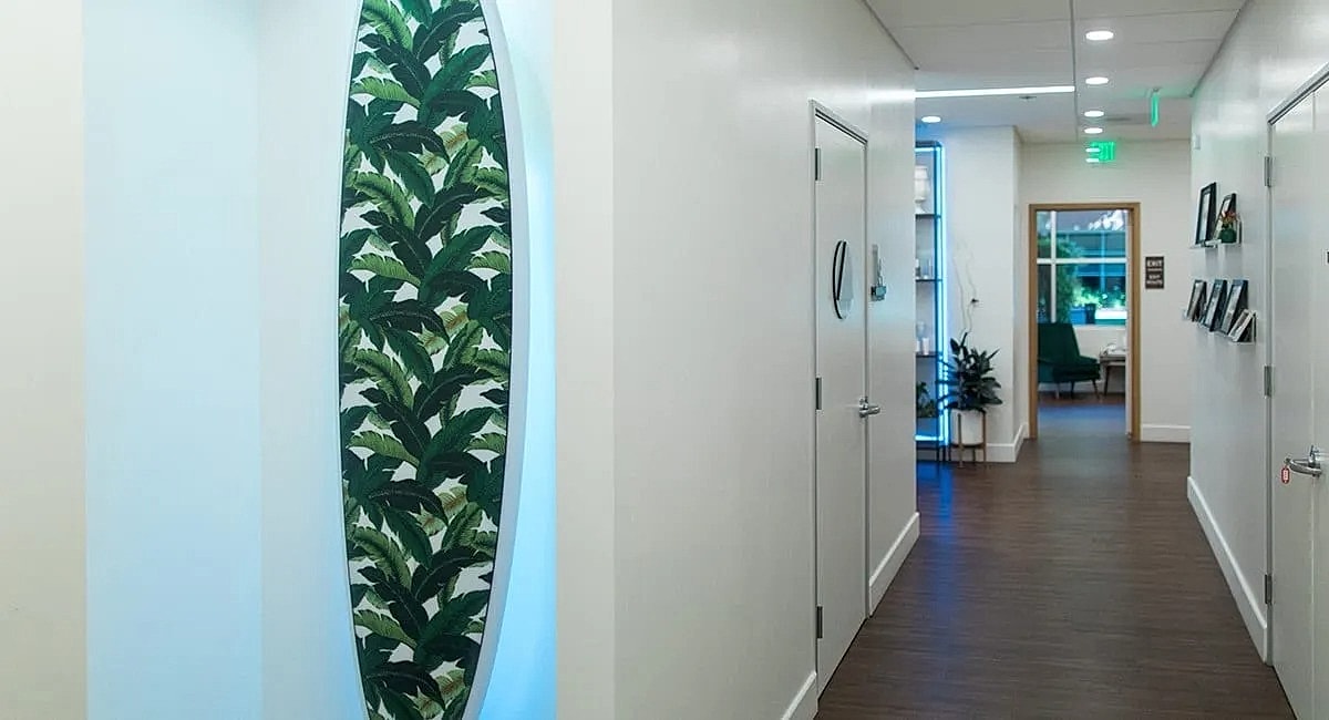 Modern hallway with tropical decor and lighting.