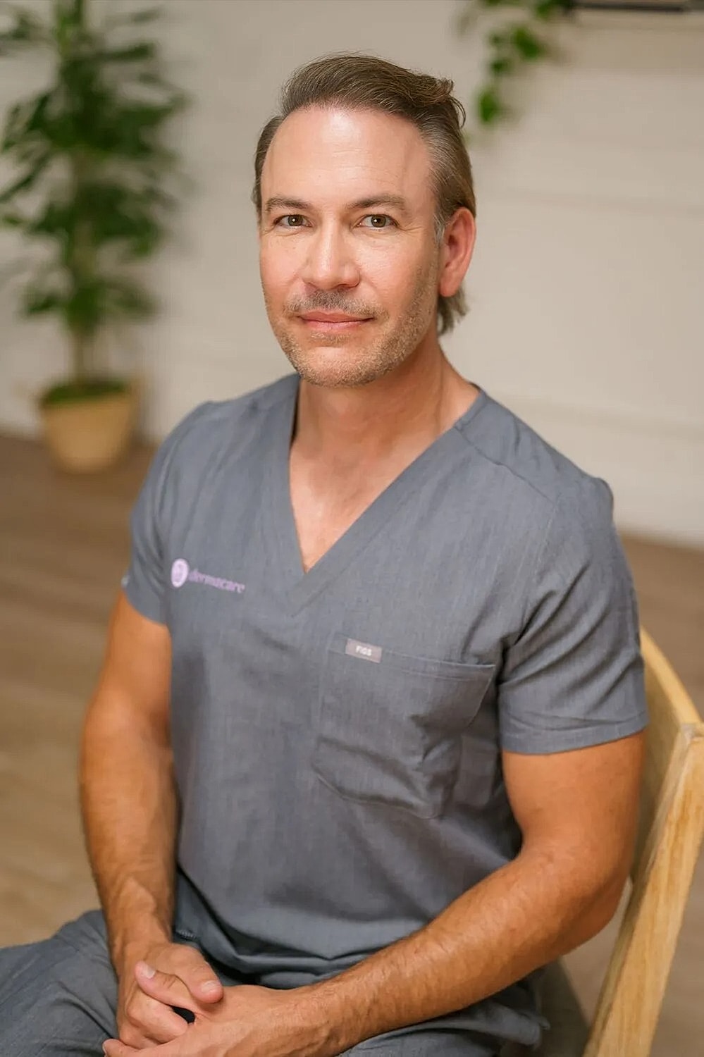 Male medical professional in gray scrubs.