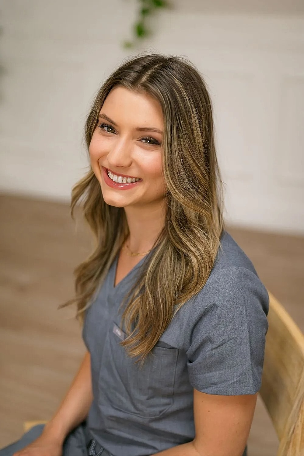 Smiling woman in a professional gray outfit.