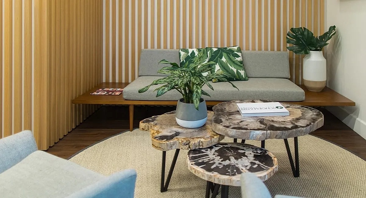 Modern lounge area with wood furniture and plants.