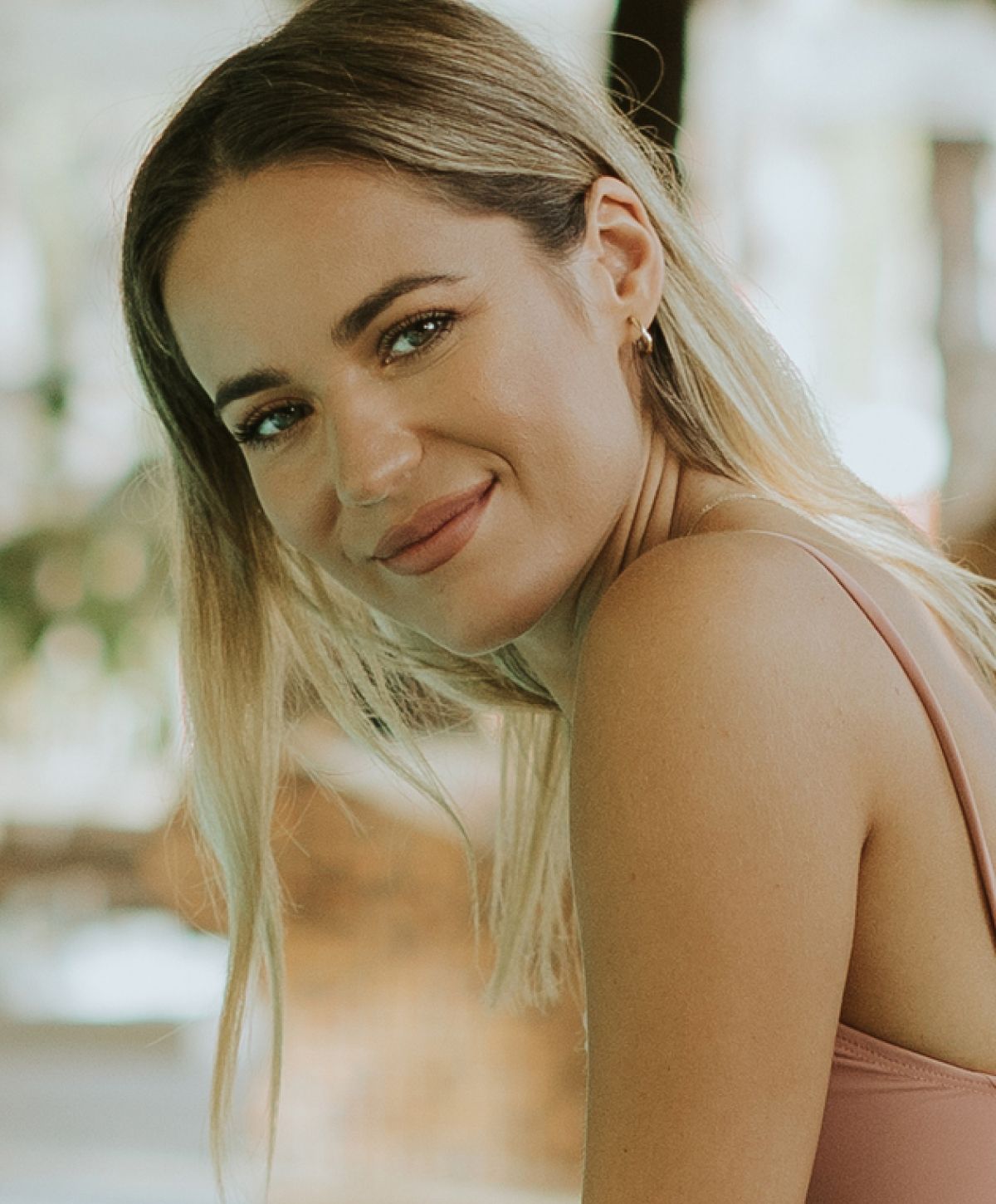 Smiling woman with long hair and soft lighting.