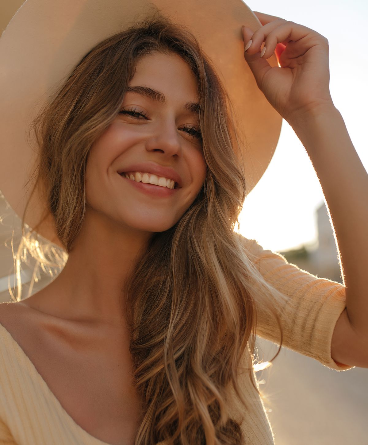 Smiling woman wearing a wide-brimmed hat.