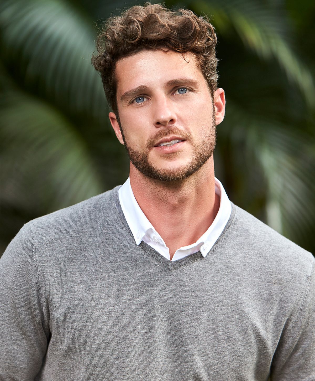 Man with curly hair in a casual sweater.