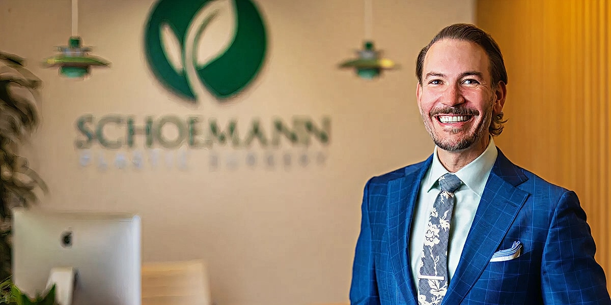 Smiling man in suit at plastic surgery office.