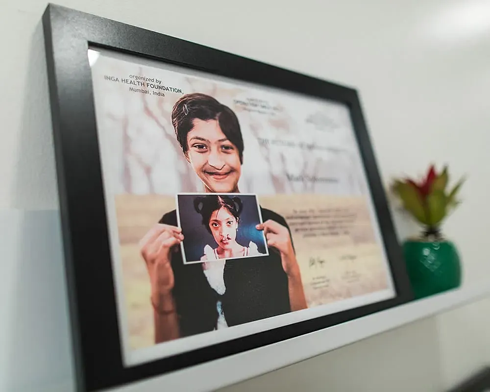 Framed photo of a smiling girl holding image.