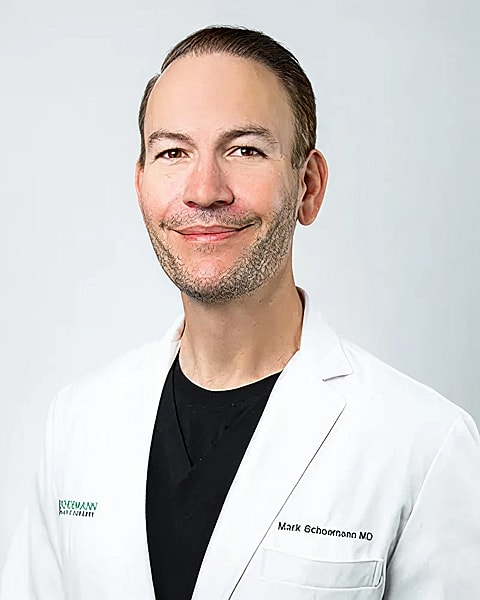 Medical professional in white coat, smiling portrait.