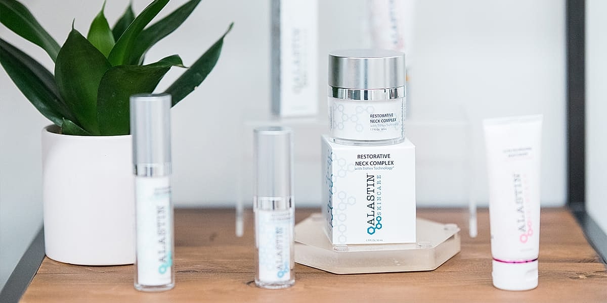 Skincare products displayed with a green plant.