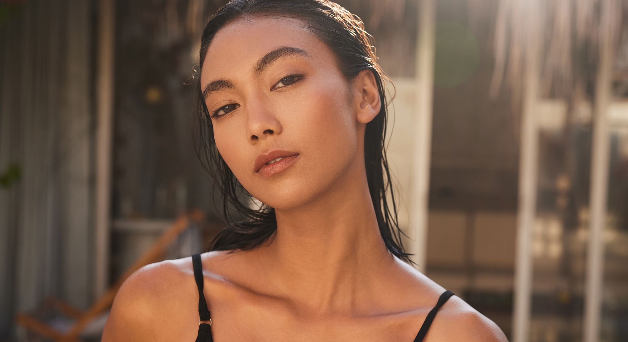 Woman with wet hair in soft sunlight.