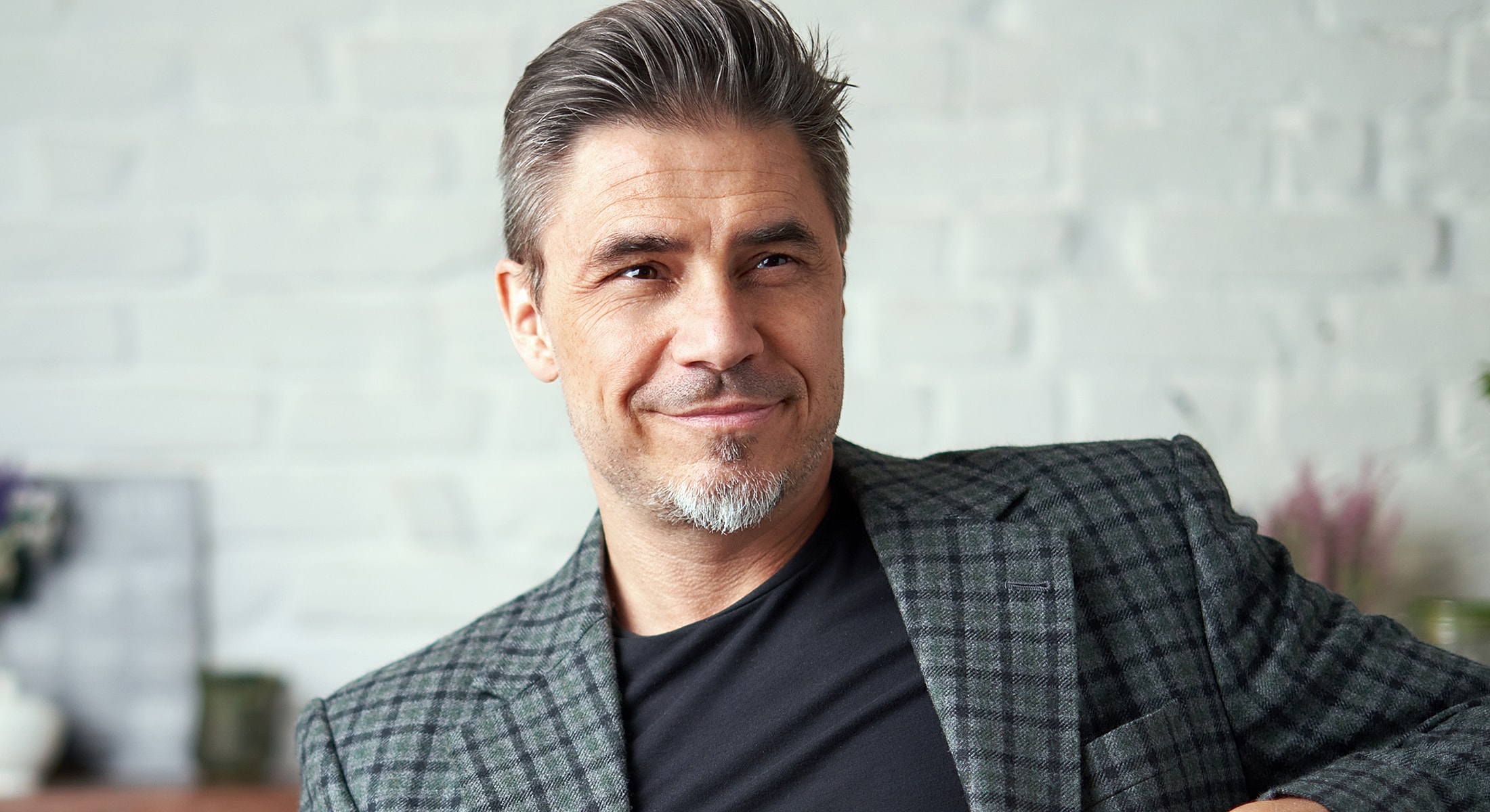 Man in a stylish blazer smiling at camera.