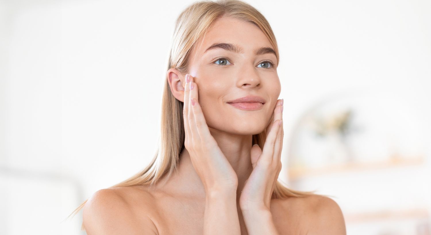 Woman applying skincare on her face.